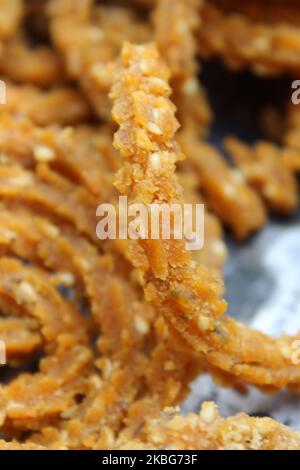 Raw chakali in plate. Indian Traditional Tea Time Snack Chakli, a deep fried snack, It is known as Chakali, Murukku, Muruku, Murkoo, Chakri. Stock Photo