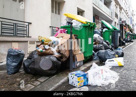 Several overflowing wheelie bins outside a house in a suburban street ...