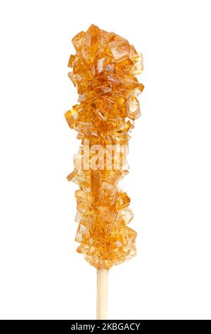 Brown rock candy, sugar candy on a wooden stick, close-up, from above, isolated, on white background. Also called rock sugar or crystal sugar. Stock Photo