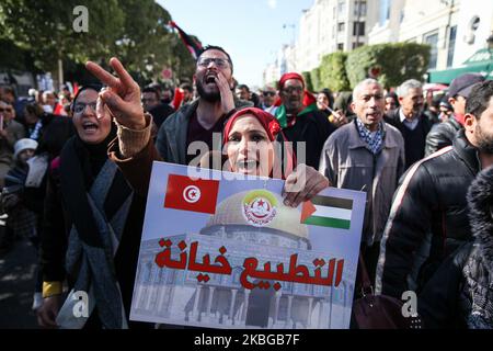 A young female protester shouts slogans and makes the victory sign while she holds a placard with a picture of the dome of the rock in Jerusalem, which reads in Arabic, ‘normalization is a betrayal’ as she attends a national march held on the main avenue Habib Bourguiba to protest against the 'peace plan' for the Middle East called the 'deal of the century' that was unveiled by US President Donald Trump, in Tunis, Tunisia on February 05, 2020. (Photo by Chedly Ben Ibrahim/NurPhoto) Stock Photo