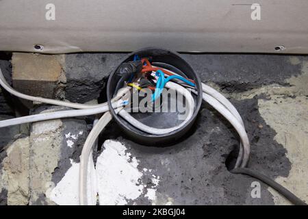 on the wall is an electric distribution box with wires Stock Photo