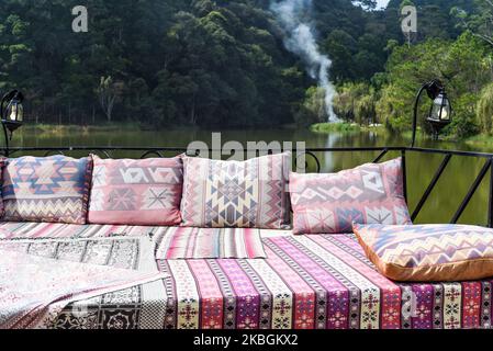 Pillows and sofa in arabian and turkish style against lake and forest Stock Photo