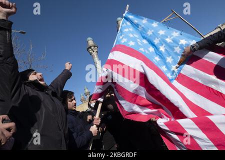 Iranian protesters shout anti-U.S. slogans as they burn the U.S. flag during a rally to mark the Islamic Revolution anniversary in Azadi (Freedom) square in western Tehran on February 11, 2020. - Thousands of Iranians massed for commemorations marking 41 years since the Islamic Revolution, in a show of unity at a time of heightened tensions with the United States. The celebrations mark the day that Shiite cleric Khomeini returned from exile and ousted the shah's last government. (Photo by Morteza Nikoubazl/NurPhoto) Stock Photo