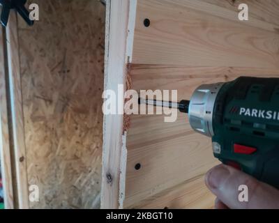 Man working inside the self converted campervan using cordless battery operated Parkside (by Lidl) drill and screwdriver for fixing the wood cladding paneling is seen in Gdansk, Poland on 8 February 2020 (Photo by Michal Fludra/NurPhoto) Stock Photo