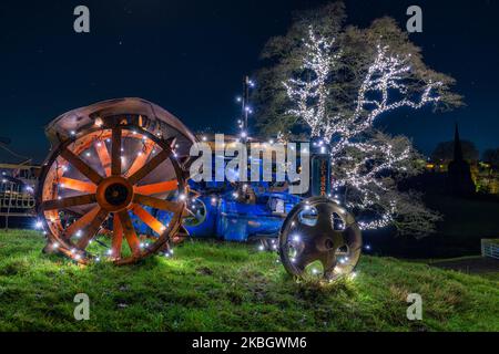 Tractor with wrapped with LED Lights with LED Covered Tree in the background Stock Photo