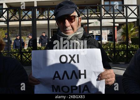 A man holds a placard that reads ''Not another Moris'' as island residents protest on February 13, 2020 in central Athens, Greece against a recent legislative act which allows the government to proceed with the requisition of properties and land in order to construct new closed migrant camps. (Photo by Nicolas Koutsokostas/NurPhoto) Stock Photo
