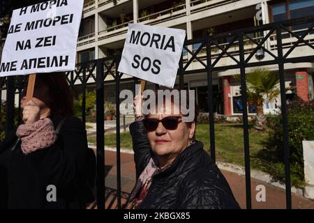 A woman holds a placard that reads ''Moria SOS'' as island residents protest on February 13, 2020 in central Athens, Greece against a recent legislative act which allows the government to proceed with the requisition of properties and land in order to construct new closed migrant camps. (Photo by Nicolas Koutsokostas/NurPhoto) Stock Photo