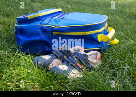 school backpack with sneakers on the grass lay Stock Photo