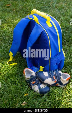 to prepare for the school year, a backpack on the grass with shoes Stock Photo