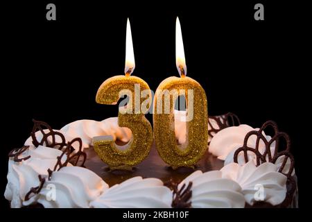 White frosted cake with 30 lit candles. 30th birthday cake Stock Photo