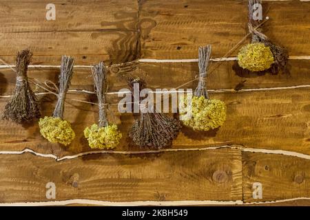 Bundles of medicinal dried herbs are the background of a wooden wall Stock Photo