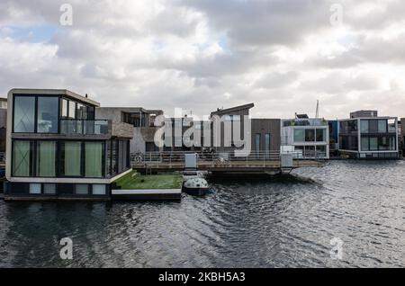 Floating houses in Amsterdam seen on February 17, 2020. Netherlands is a country protected by dykes where people live on human-made mounds which rise them above sea level, and in the water on floating homes. Houseboats ore floating hotels can be seen along the canals in Amsterdam and other cities. Floating homes were suggested as a viable, ecofriendly and sustainable solution to the housing needs of modern Holland. An example of floating homes in Amsterdam is on Steigereiland, the first island constructed part of the human-made Ijburg archipelago on the Eastern part of the city. This island wa Stock Photo
