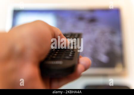 A person using the remote control of a television. Stock Photo