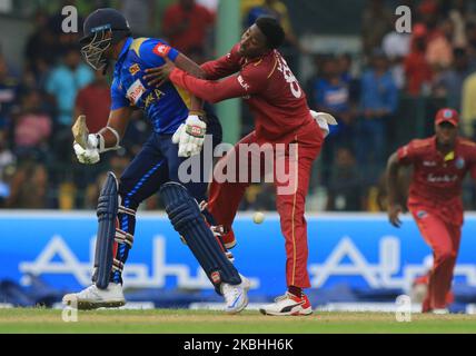 Sri Lankan cricketer Thisara Perera (L) reacts as West Indies cricketer Fabian Allen tries to stop the ball during the 1st One Day International cricket match between Sri Lanka and West Indies at SSC international cricket ground, Colombo, Sri Lanka. Saturday 22 February 2020 (Photo by Tharaka Basnayaka/NurPhoto) Stock Photo