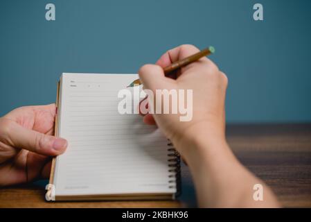 2023 Happy New Year Resolution Goal List, Hand with pen writing on notebook with copy space, plan listing of new year goals and resolutions setting. C Stock Photo
