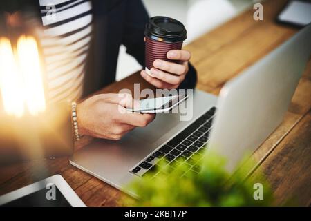 The gadgets that get things done. a businessman using a mobile phone and laptop at his work desk. Stock Photo