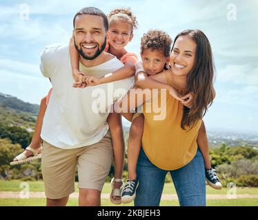 Happy family, mother and father with children on back in a nature park for bonding and relaxing in summer. Smile, mom an dad love enjoying quality Stock Photo