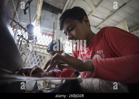 Handloom weaver weaves Jamdani saree on a traditional wooden hand weaving loom at Demra Jamdani Palli, in Dhaka, Bangladesh on March 06, 2020. (Photo by Ahmed Salahuddin/NurPhoto) Stock Photo