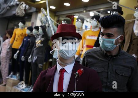A Palestinian merchant stands wearing a health face mask, due to fears of spread of COVID-19 coronavirus disease, outside his clothing shop in Gaza City on March 7, 2020. (Photo by Majdi Fathi/NurPhoto) Stock Photo