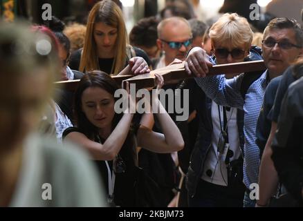 Pilgrims carry a cross on the Via Dolorosa processional route in Jerusalem Old city. With 29 Israelis and 19 Palestinians tested positive for coronavirus so far and thousands placed in isolation, Israel may expand coronavirus quarantine to all countries. On Sunday, March 8, 2020, in Jerusalem, Israel. (Photo by Artur Widak/NurPhoto) Stock Photo