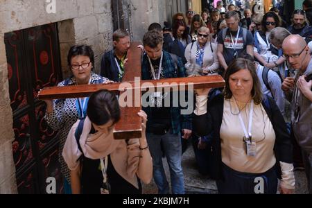 Pilgrims carry a cross on the Via Dolorosa processional route in Jerusalem Old city. With 29 Israelis and 19 Palestinians tested positive for coronavirus so far and thousands placed in isolation, Israel may expand coronavirus quarantine to all countries. On Sunday, March 8, 2020, in Jerusalem, Israel. (Photo by Artur Widak/NurPhoto) Stock Photo