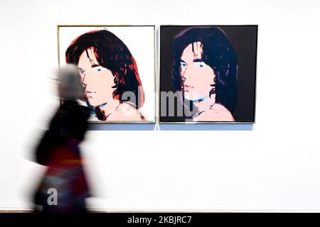 A gallery assistant poses with an artwork entitled Mick Jagger, 1980', by US artist Andy Warhol during a press preview for the forthcoming Andy Warhol exhibition at the Tate Modern in London on March 10, 2020. - The exhibition is set to run from March 12 to September 6. RESTRICTED TO EDITORIAL USE - MANDATORY MENTION OF THE ARTIST UPON PUBLICATION - TO ILLUSTRATE THE EVENT AS SPECIFIED IN THE CAPTION (Photo by Alberto Pezzali/NurPhoto) Stock Photo