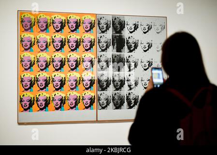A gallery assistant poses with an artwork entitled 'Marilyn Diptych' 1962,' by US artist Andy Warhol during a press preview for the forthcoming Andy Warhol exhibition at the Tate Modern in London on March 10, 2020. - The exhibition is set to run from March 12 to September 6. (RESTRICTED TO EDITORIAL USE - MANDATORY MENTION OF THE ARTIST UPON PUBLICATION - TO ILLUSTRATE THE EVENT AS SPECIFIED IN THE CAPTION) (Photo by Alberto Pezzali/NurPhoto) Stock Photo