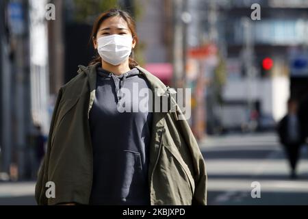 A woman, wearing protective mask following an outbreak of the coronavirus disease (COVID-19), walks in Tokyo, Japan, March 13, 2020. (Photo by Hitoshi Yamada/NurPhoto) Stock Photo