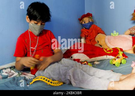 A boy wearing a face mask to prevent coronavirus on March 16, 2020 in Dhaka, Bangladesh. Due to the threat of Corona virus (COVID - 19) Bangladeshi authority has already been shutdown all the educational institutions and all the ports. People are getting panicked though slowly. A family staying at home wearing masks. Children also masked their dolls while playing in side their home. (Photo by Khandaker Azizur Rahman Sumon/NurPhoto) Stock Photo