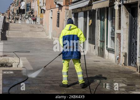 Workers wash and disinfect as special street cleaning made by the Municipality Company Veritas in the area of Cannaregio, Venice, Italy, on March 17, 2020 using a pressure washer installed on a boat during Covid-19 Emergency. (Photo by Giacomo Cosua/NurPhoto) Stock Photo