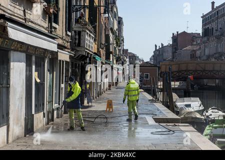 Workers wash and disinfect as special street cleaning made by the Municipality Company Veritas in the area of Cannaregio, Venice, Italy, on March 17, 2020 using a pressure washer installed on a boat during Covid-19 Emergency. (Photo by Giacomo Cosua/NurPhoto) Stock Photo