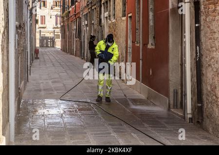 Workers wash and disinfect as special street cleaning made by the Municipality Company Veritas in the area of Cannaregio, Venice, Italy, on March 17, 2020 using a pressure washer installed on a boat during Covid-19 Emergency. (Photo by Giacomo Cosua/NurPhoto) Stock Photo