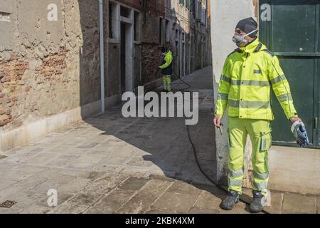 Workers wash and disinfect as special street cleaning made by the Municipality Company Veritas in the area of Cannaregio, Venice, Italy, on March 17, 2020 using a pressure washer installed on a boat during Covid-19 Emergency. (Photo by Giacomo Cosua/NurPhoto) Stock Photo