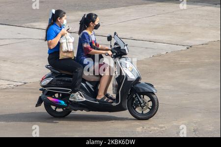 SAMUT PRAKAN, THAILAND, SEP 23 2022, Two women rides on motorcycle at the street. Stock Photo