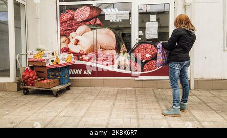 Woman with protective mask is seen waiting to go inside a shop in one of the biggest green market in Varna, Bulgaria, on March 18, 2020. The Bulgarian government banned people from gathering in groups. Restaurants and bakeries can only sell food for home. Coffee shops, night clubs theaters and cinemas are closed. Employees are encouraged to work from. This is done to prevent the spread of COVID-19. In the following month only governmental institutions, pharmacies and food shops will be open. Department of Health has confirmed 92 cases of coronavirus in Bulgaria, with at least two recorded fata Stock Photo