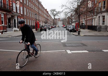 A man rides a bike along near-deserted streets in the Bloomsbury district of London, England, on March 19, 2020. Amid the ongoing covid-19 coronavirus crisis the British government today sought to quash mounting speculation of an imminent lockdown of the city involving restrictions on movement. New measures for pubs, cafes, bars and theatres are however expected to be announced shortly. Earlier, it was announced that 40 London Underground stations are to be closed as Transport for London begins scaling back its services, and many public spaces and streets in the capital today were visibly empt Stock Photo