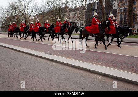 Members of the Household Cavalry ride through Hyde Park in London, England, on March 20, 2020. In the UK it has been revealed today that the government's Scientific Advisory Group for Emergencies (SAGE) has recommended keeping some form of 'social distancing' measures in place for most of a year, with alternating periods of less and more strict restrictions over that time, in order to manage the spread of the covid-19 coronavirus and prevent an overwhelming of hospitals. Schools are meanwhile closing today across the country until further notice, with exceptions for vulnerable children and chi Stock Photo