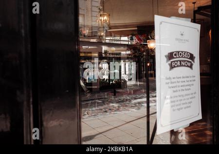 Wine glasses hang from an overhead rack at a closed pub in the Seven Dials neighbourhood of London, England, on March 21, 2020. Much of central London was virtually empty today, a day after British Prime Minister Boris Johnson ordered the closure of all pubs, bars, cafes and restaurants around the country. The move represents a toughening of measures to enforce the 'social distancing' that is being urged on citizens to reduce the growth of covid-19 coronavirus infections. Nightclubs, theatres, cinemas, gyms and leisure centres were also ordered closed. Some shops in the centre of capital remai Stock Photo