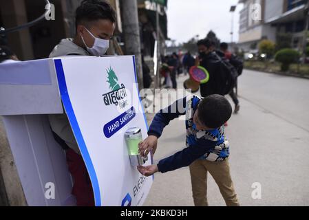 A kid using mobile Hand sanitizer which stop spread and cause of Corona Virus (COVID-19) around the crowed area in Kathmandu, Nepal on Sunday, March 22, 2020. (Photo by Narayan Maharjan/NurPhoto) Stock Photo