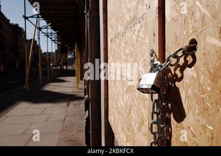 A padlock secures a boarded-up branch of sandwich chain Eat on a near-deserted Fleet Street in London, England, on March 24, 2020. British Prime Minister Boris Johnson yesterday evening instigated an unprecedented UK 'lockdown' to combat the spread of the covid-19 coronavirus, instructing citizens not to leave their homes other than to buy essentials, for medical reasons and to provide care, to travel to and from work if 'absolutely necessary', and to exercise once a day. All shops selling non-essential goods were ordered to close. A further 87 people were today announced to have died from the Stock Photo