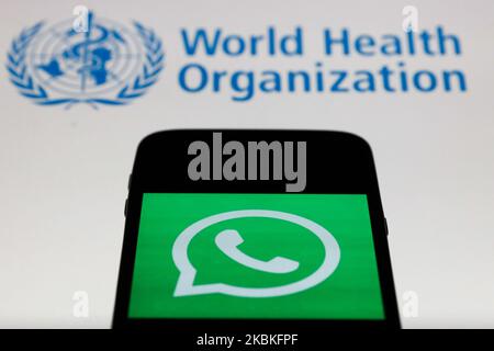 WhatsApp app icon is seen on the smartphone screen with World Health Organization ( WHO ) logo in the background in this illustration photo taken in Poland on March 24, 2020. (Photo illustration by Jakub Porzycki/NurPhoto) Stock Photo