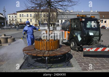 A worker of Municipal Cleaning Company (MPO) uses a pressure hose to disinfect bus and tram stop as well as public squares with cleaning agents against the spread of coronavirus. Krakow, Poland on March 27, 2020. Poland's government decided to introduce new limitations across the country, such as rules preventing leaving home unless justified. (Photo by Beata Zawrzel/NurPhoto) Stock Photo