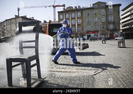 A worker of Municipal Cleaning Company (MPO) uses a pressure hose to disinfect bus and tram stop as well as public squares with cleaning agents against the spread of coronavirus. Krakow, Poland on March 27, 2020. Poland's government decided to introduce new limitations across the country, such as rules preventing leaving home unless justified. (Photo by Beata Zawrzel/NurPhoto) Stock Photo