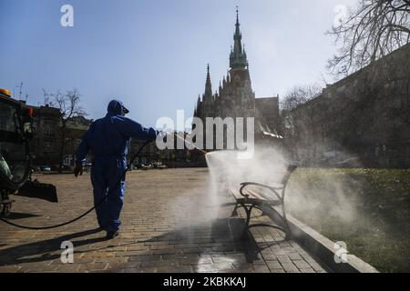 A worker of Municipal Cleaning Company (MPO) uses a pressure hose to disinfect bus and tram stop as well as public squares with cleaning agents against the spread of coronavirus. Krakow, Poland on March 27, 2020. Poland's government decided to introduce new limitations across the country, such as rules preventing leaving home unless justified. (Photo by Beata Zawrzel/NurPhoto) Stock Photo