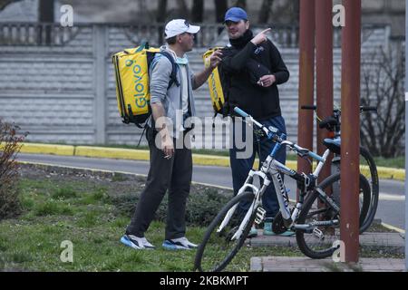 Food couriers in protective masks as a preventive measure against the coronavirus COVID-19 wait for orders near of fast food restaurant to deliver it to clients in Kyiv, Ukraine, 28 March 2020. Ukraine's Cabinet introduced a national emergency for 30 days, till 24 April 2020 (Photo by Maxym Marusenko/NurPhoto) Stock Photo