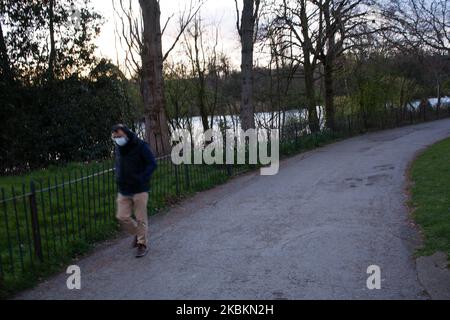 A man wearing a mask walks through Kensington Gardens in London, England, on March 28, 2020. The UK today began its first weekend under the covid-19 coronavirus lockdown conditions imposed by British Prime Minister Boris Johnson on Monday evening, under which people can leave their homes only for buying essentials, exercising, providing care and, if unavoidable, to travel to and from work. UK deaths currently stand at 1,019, after 260 more were reported to have died over the past 24 hours. (Photo by David Cliff/NurPhoto) Stock Photo