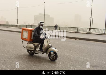 A man wearing face mask rides a motorcycle during a sandstorm in Cairo, Egypt, 05 April 2020 (Photo by Ziad Ahmed/NurPhoto) Stock Photo