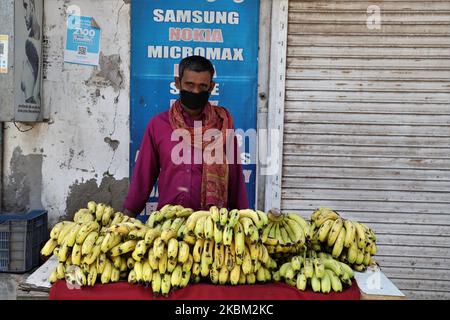 A vendor wearing a mask sells fruits in Gurugram on the outskirts of New Delhi amid COVID-19 (coronavirus) Lock down on 07 April 2020. To combat the spread of deadly COVID-19, PM of India Narendra Modi has recently announced a 21-day lockdown. However, the curfew-like situation has forced migrant workers to return to their homes when traffic is entirely off the roads apart from the railway and air traffic. So much so, many workers are left stranded with no food, shelter and other necessities. The lockdown has also enforced multi-national companies to fire thousands of employees amid the Corona Stock Photo