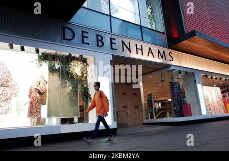 A woman walks past the boarded-up flagship branch of department store chain Debenhams on a near-deserted Oxford Street in London, England, on April 6, 2020. Debenhams announced today that it was having to file for administration as a consequence of having to shut all its stores across the UK under the covid-19 coronavirus lockdown. This is to be the second time in a year that the struggling retailer has filed for administration. Its present predicament comes not long after its permanent closure of 22 stores, resulting in more than 700 job losses, with a further 28 already slated for closure in