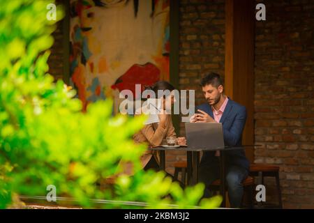 Two business guys are resting after work, sitting in a cafe bar, on beautiful sunny day Stock Photo